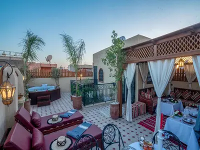 a patio with tables and chairs on a balcony at Riad Le Nid De Fatima in Marrakech