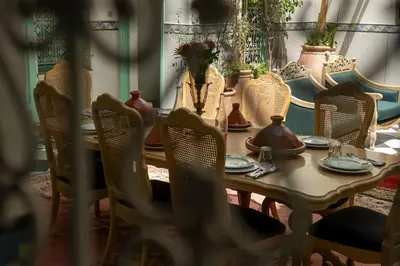 a table with chairs and plates and vases on it at Charming Medina Riad 8 rooms with pool - Riad INN Medina in Marrakech