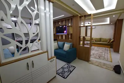 a living room with a blue couch and a tv at Appartement familial proche aéroport et Oasiria in Marrakech