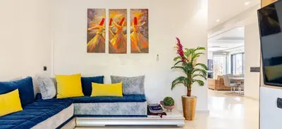 a living room with a blue couch with yellow pillows at Exotic villa-VIP-family only -housekeeper ,Billard,ping-pong,piscine privée chauffée-sur demande- in Marrakech