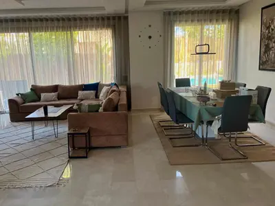a living room with a table and a couch at Exotic villa-VIP-family only -housekeeper ,Billard,ping-pong,piscine privée chauffée-sur demande- in Marrakech
