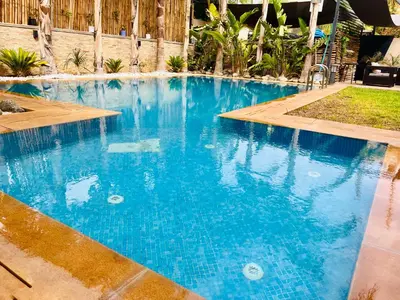 a large swimming pool with blue water at Exotic villa-VIP-family only -housekeeper ,Billard,ping-pong,piscine privée chauffée-sur demande- in Marrakech