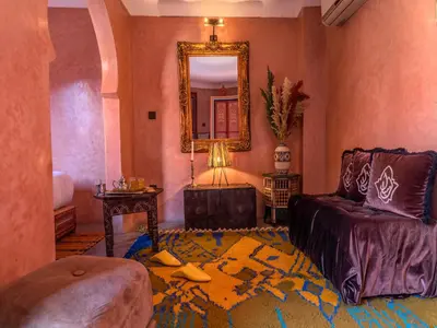 a living room with a couch and a mirror at Riad Irhalne in Marrakech