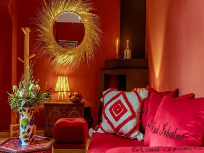 a red room with a red couch and a mirror at Riad Irhalne in Marrakech