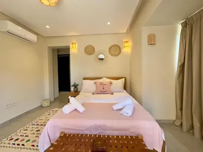 a bedroom with a pink bed with towels on it at Villa Oasis in Marrakech