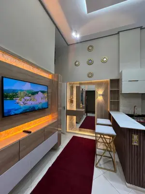 a kitchen with a flat screen tv and a bar at Appartement 1 chambre in Marrakech