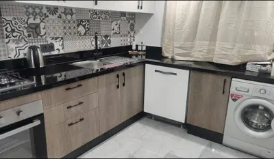 a kitchen with a sink and a washing machine at Élégant duplex avec deux piscines et une vue magnifique in Marrakech