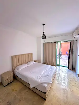 a bedroom with a white bed and a large window at Duplex Mirador Majorelle in Marrakech