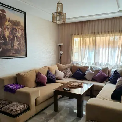 a living room with a couch and a table at Appartement près du hôtel IBIS et WAZO et Marjane Mall in Marrakech