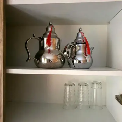 two tea pots and cups on a shelf at Appartement près du hôtel IBIS et WAZO et Marjane Mall in Marrakech