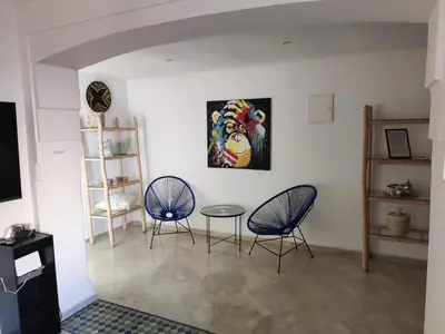 a room with two chairs and a table and a painting at Appartement à Marrakech Babylon 2 Hivernage in Marrakech