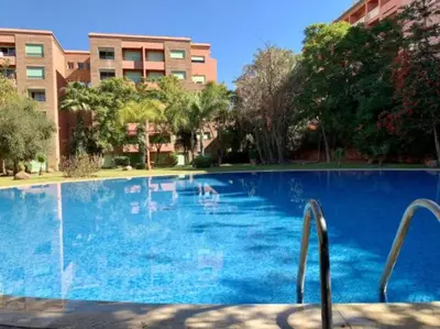 a large blue swimming pool in a building at Appartement à Marrakech Babylon 2 Hivernage in Marrakech