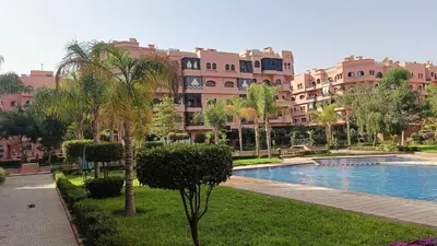 a resort with a swimming pool and palm trees at premium village M355 in Marrakech