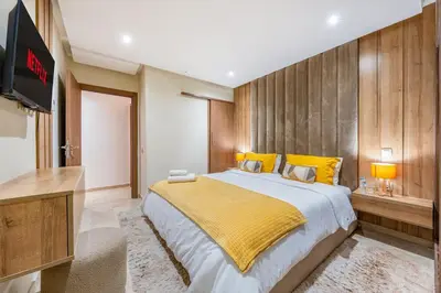 a bedroom with a large bed and a flat screen tv at Appartement chic Gueliz kasbel 211 in Marrakech