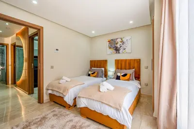 a bedroom with two beds and a mirror at Appartement chic Gueliz kasbel 211 in Marrakech