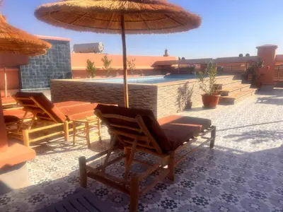 a patio with chairs and a table with an umbrella at Appartement chic Gueliz kasbel 211 in Marrakech