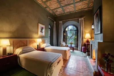 a hotel room with two beds and a fireplace at Dar Zemora in Marrakech