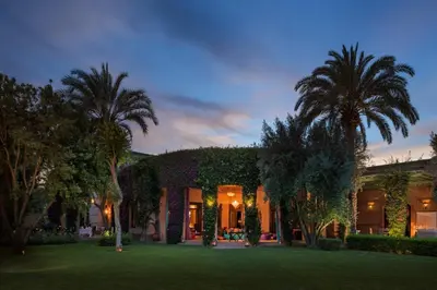 a house with palm trees in front of a yard at Dar Zemora in Marrakech
