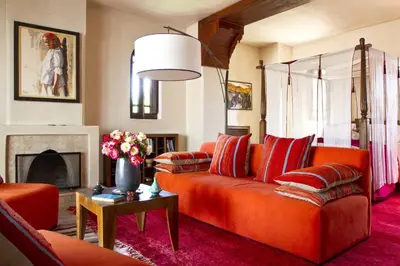 a living room with an orange couch and a fireplace at Dar Zemora in Marrakech