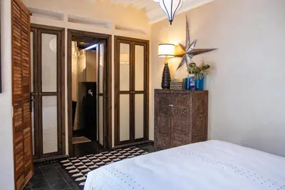 a bedroom with a bed and a dresser and a mirror at Riad Lulua Exclusif 3 Chambres et Piscine Rooftop in Marrakech