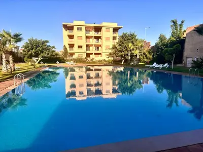 a large pool of blue water in front of a building at Luxuswohnung in Residence Coralia les orangers in Marrakech
