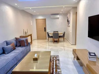 a living room with a couch and a table at Luxuswohnung in Residence Coralia les orangers in Marrakech