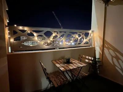 a balcony with a table and chairs and lights at Green appart Marrakech by Kamal in Marrakech