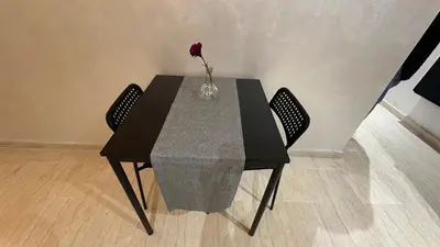a black table with a vase with a flower on it at Green appart Marrakech by Kamal in Marrakech