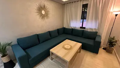 a living room with a blue couch and a coffee table at Green appart Marrakech by Kamal in Marrakech