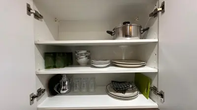 a white cupboard with some dishes and a pot on it at Green appart Marrakech by Kamal in Marrakech