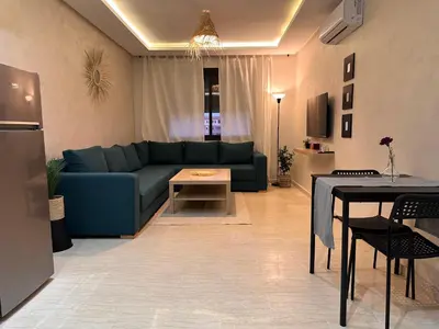 a living room with a blue couch and a table at Green appart Marrakech by Kamal in Marrakech