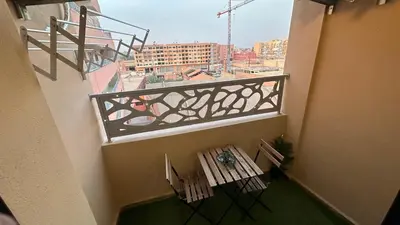 a balcony with a table and chairs on a building at Green appart Marrakech by Kamal in Marrakech