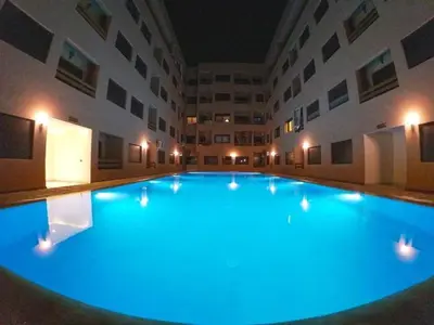 a large swimming pool in a building with blue lighting at Appartement luxueux 38 nour 5 in Marrakech