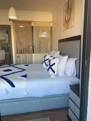 a bedroom with a bed with white and blue pillows at Appartement luxueux 38 nour 5 in Marrakech