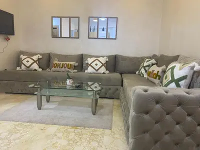 a living room with a couch and a glass table at Appartement luxueux 38 nour 5 in Marrakech