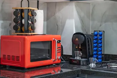a red microwave sitting on top of a kitchen counter at Appartement de prestige Gueliz kasbel 212 in Marrakech