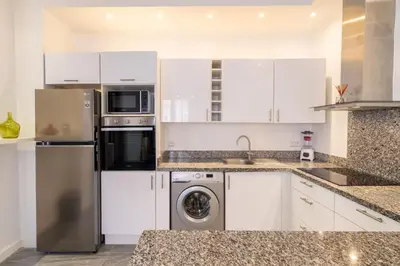 a kitchen with white cabinets and a washer and dryer at appartement hyper centre in Marrakech