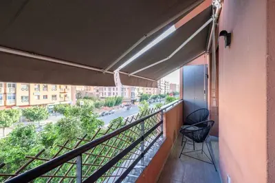 a balcony with two chairs and a view of a street at appartement hyper centre in Marrakech