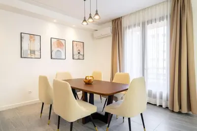 a dining room with a wooden table and white chairs at appartement hyper centre in Marrakech