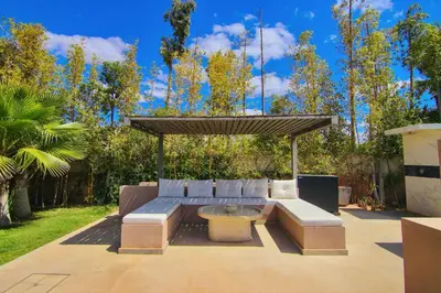 a patio with a couch and a table at Villa SELINA Luxury -5 suites , Piscine privée chauffée, sans vis à vis, calme & sureté - Padle , Family only in Marrakech