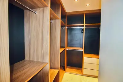 a walk in closet with wooden cabinets at Villa SELINA Luxury -5 suites , Piscine privée chauffée, sans vis à vis, calme & sureté - Padle , Family only in Marrakech