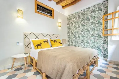 a bedroom with a bed with yellow pillows at Riad Les Suites Marrakech in Marrakech