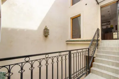 a stairway with a black railing next to a building at Riad Les Suites Marrakech in Marrakech