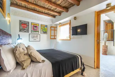 a bedroom with a bed with a stuffed animal on it at Riad Les Suites Marrakech in Marrakech