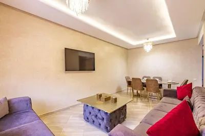 a living room with a couch and a table at New! App Émeraude Confort avec piscine & parking in Marrakech