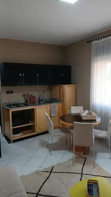 a kitchen with a table and a table and chairs at APPARTENT 11 à GUELIZE HIVERNAGE in Marrakech