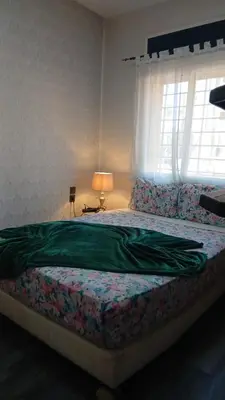 a bedroom with a bed with a green blanket on it at APPARTENT 11 à GUELIZE HIVERNAGE in Marrakech