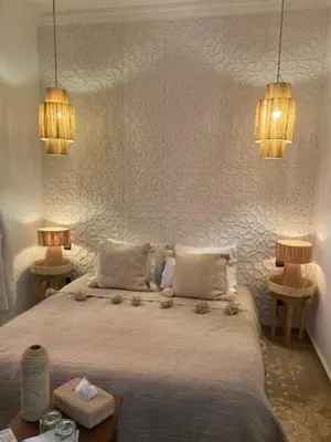 a bedroom with a bed with two lamps and two tables at Riad Cosy in Marrakech