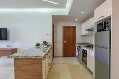 a kitchen with a refrigerator and a counter top at Red appart in Marrakech