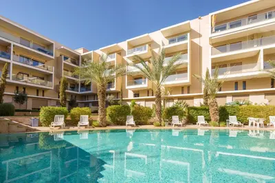 a swimming pool in front of a building at Red appart in Marrakech